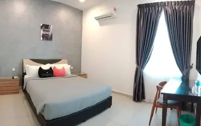 a bedroom with a bed and a desk and a computer at Austin GuestHouse in Ipoh