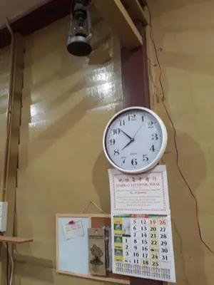 a clock hanging on a wall with a calendar at Teratak Opah Kamunting in Taiping