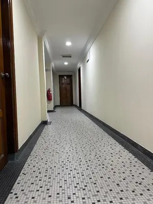 an empty hallway with a door and a tiled floor at New Caspian Hotel in Ipoh