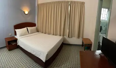 a hotel room with a bed and a window at New Caspian Hotel in Ipoh