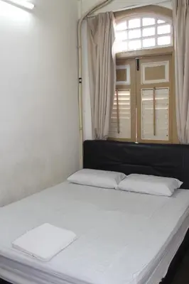 a bed in a room with a window at Old Penang Hotel - Trang Road in George Town