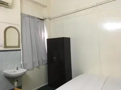 a bathroom with a bed and a sink and a mirror at Old Penang Hotel - Trang Road in George Town
