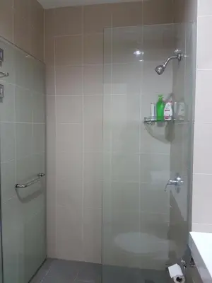 a bathroom with a shower with a glass door at 118 Suite in George Town