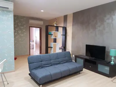 a living room with a blue couch and a tv at 118 Suite in George Town