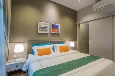 a bedroom with a bed with orange and blue pillows at Meru Suites at Meru Valley Resort in Ipoh