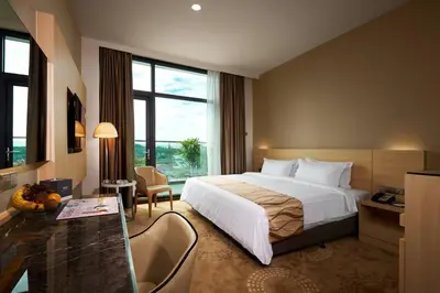 a hotel room with a large bed and a desk at Purest Hotel Sungai Petani in Sungai Petani