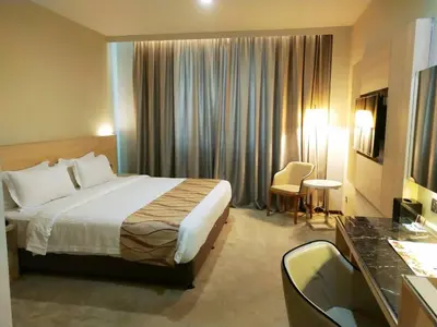 a hotel room with a bed and a desk at Purest Hotel Sungai Petani in Sungai Petani