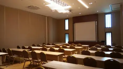 a lecture room with tables and chairs and a whiteboard at Purest Hotel Sungai Petani in Sungai Petani