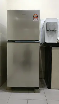 a refrigerator in a kitchen next to a counter at The Louvre Moslim Homestay Sungai Petani in Sungai Petani