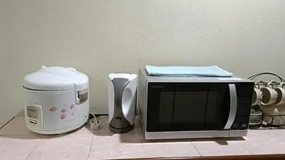 a microwave and a coffeemaker sitting on a counter at The Louvre Moslim Homestay Sungai Petani in Sungai Petani