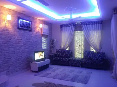 a living room with a couch and a tv at The Louvre Moslim Homestay Sungai Petani in Sungai Petani