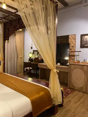 a bedroom with a bed and a desk with a television at ke-lan-tan House in George Town