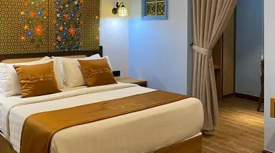 a bedroom with a large bed with a painting on the wall at ke-lan-tan House in George Town