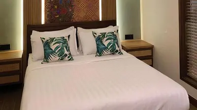 a bedroom with a bed with white sheets and pillows at ke-lan-tan House in George Town