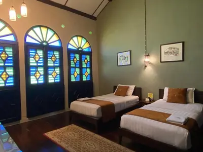 two beds in a room with stained glass windows at ke-lan-tan House in George Town