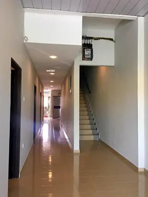 a hallway with stairs and a clock on the wall at Lunas Bliss in Lunas