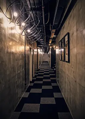 a long hallway with a tile floor and lights at Merton Hotel Ipoh in Ipoh