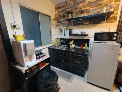 a small kitchen with a refrigerator and a sink at The Mons inside Tower Regency Hotel and Apartments in Ipoh