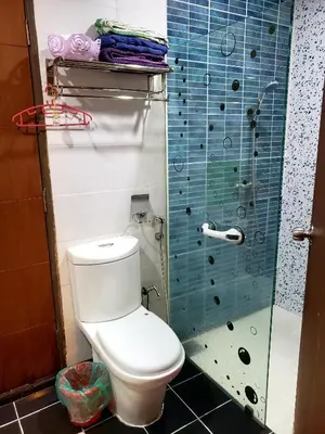 a bathroom with a toilet and a glass shower at The Mons inside Tower Regency Hotel and Apartments in Ipoh