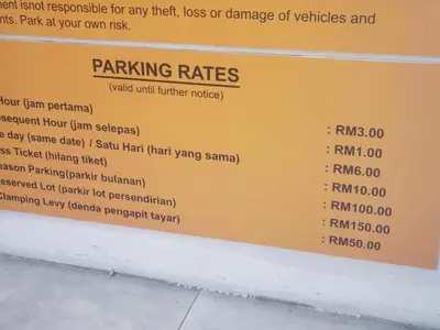 a sign for parking rates at a restaurant at The Mons inside Tower Regency Hotel and Apartments in Ipoh