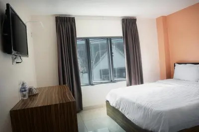 a bedroom with a bed and a large window at Brezza Hotel Lumut in Lumut