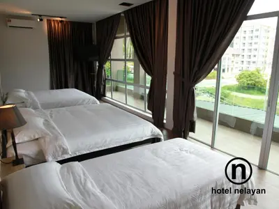 two beds in a hotel room with a window at Hotel Nelayan in Pangkor