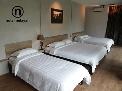 a group of three beds in a hotel room at Hotel Nelayan in Pangkor