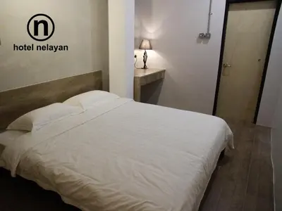 a white bed in a room with a hotel melanie sign at Hotel Nelayan in Pangkor