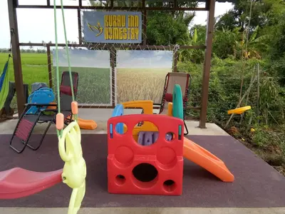 a play area with swings and a swing set at Kurau Inn Boutique Farmstay in Kuala Kurau
