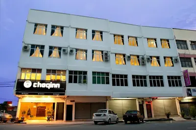 a building with a car parked in front of it at Hotel Cheqinn in Ipoh