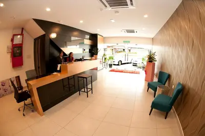 a lobby of a hospital with a counter and chairs at Hotel Cheqinn in Ipoh