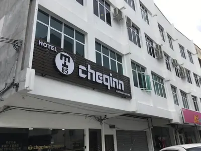 a white building with a sign for a hotel at Hotel Cheqinn in Ipoh