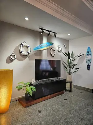 a living room with a flat screen tv on a wall at Little Heaven by Sky Hive, A Beach Front Bungalow in Tanjung Bungah