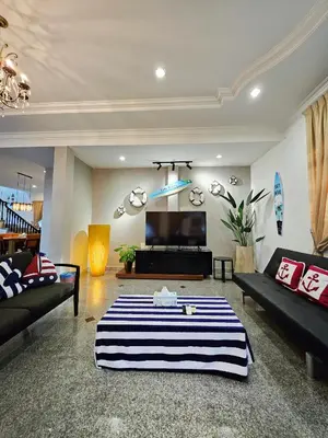 a living room with a couch and a tv at Little Heaven by Sky Hive, A Beach Front Bungalow in Tanjung Bungah