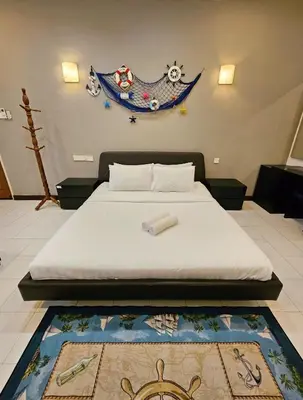 a bedroom with a bed and a rug on the floor at Little Heaven by Sky Hive, A Beach Front Bungalow in Tanjung Bungah