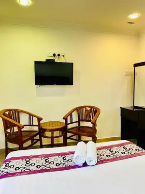 a room with two beds and a flat screen tv at Hotel Sagittario in Ipoh