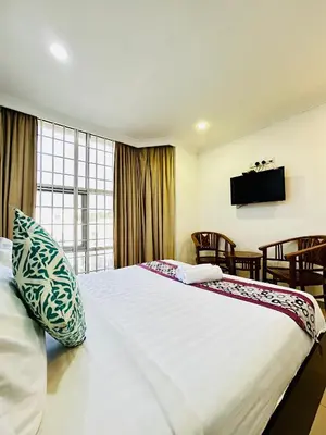 a hotel room with a large bed with a tv on the wall at Hotel Sagittario in Ipoh