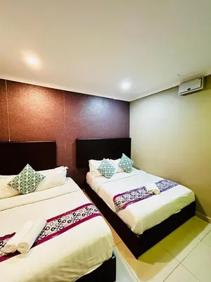 two beds in a hotel room with at Hotel Sagittario in Ipoh