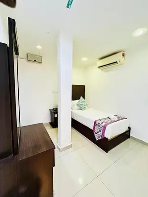 a bedroom with a bed and a tv in it at Hotel Sagittario in Ipoh