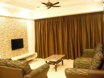 a living room with two couches and a television at Lacy's Crown Imperial Court Apartment in Cameron Highlands