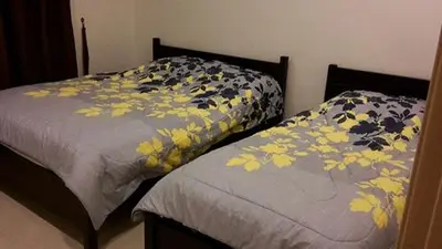 two beds sitting next to each other in a bedroom at Lacy's Crown Imperial Court Apartment in Cameron Highlands