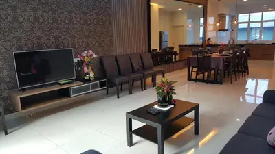 a living room with a tv and chairs and a table at Shamrock Villas Corner OR Seaview OR Standard in Batu Ferringhi