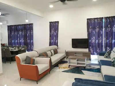 a living room with couches and a tv and a table at Shamrock Villas Corner OR Seaview OR Standard in Batu Ferringhi