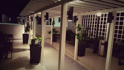 a hallway with potted plants on a building at night at Dephane Apartment in Cameron Highlands