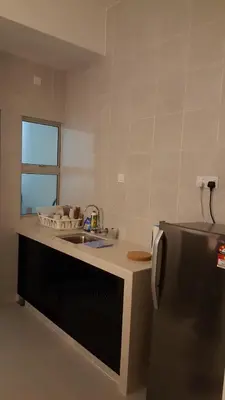 a kitchen with a sink and a refrigerator at Dephane Apartment in Cameron Highlands