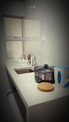 a kitchen counter with a sink and a pot on a counter at Dephane Apartment in Cameron Highlands