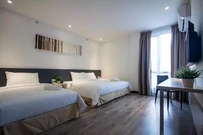 a hotel room with two beds and a table at Fuller Hotel Kulim in Kulim