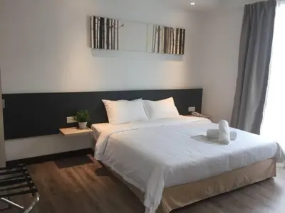 a bedroom with a large bed with white sheets at Fuller Hotel Kulim in Kulim