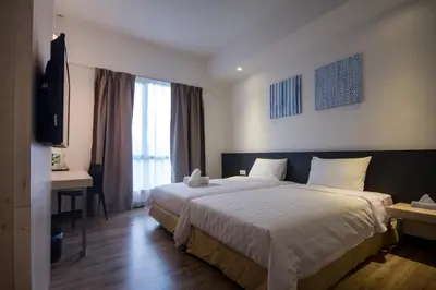 a hotel room with a large bed and a television at Fuller Hotel Kulim in Kulim