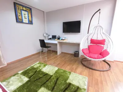 a room with a hanging chair and a desk at Royale Hotel Batu Gajah in Ipoh